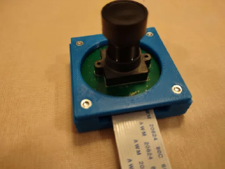 The first and second versions of my IMX462 camera holder, along with screws and nuts
