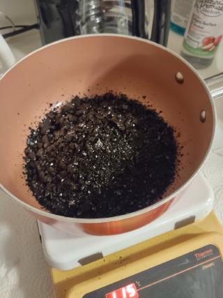 Cold pitch fresh out of the storage container, in a pot being heated up. It looks like a bag of rocks or gravel.