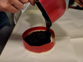 Hot pitch flowing like honey and being poured out of the pan