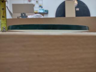 The draped glass blank viewed from the side. The kiln has curved it so its sides are 1/4" above the table its center rests on.