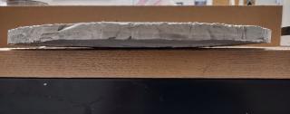 The furnace cement tool that helped curve the glass. It almost seems to have bent itself upside-down; the top part (which used to be curved) is flat and the bottom part (which used to be flat) is curved.