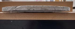 The furnace cement tool that helped curve the glass. It almost seems to have bent itself upside-down; the top part (which used to be curved) is flat and the bottom part (which used to be flat) is curved.