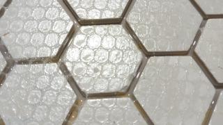 Closeup of my new tool after curing and removing the webbing. The epoxy seems to have created a smooth bottom layer that the tiles are embedded in, but some of those gaps have a bit of an epoxy ceiling thanks to the epoxy climbing the walls and getting caught under the webbing 