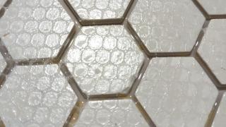 Closeup of my new tool after curing and removing the webbing. The epoxy seems to have created a smooth bottom layer that the tiles are embedded in, but some of those gaps have a bit of an epoxy ceiling thanks to the epoxy climbing the walls and getting caught under the webbing 