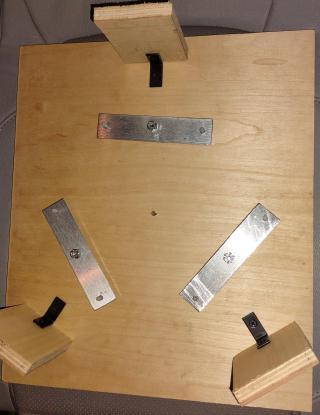 This mirror cell distributes the mirror's weight across 6 points, divided up into three bars that are loose and can pivot to redistribute the weight. When vertical it rests on two wooden blocks at bottom - better mirror cells have more